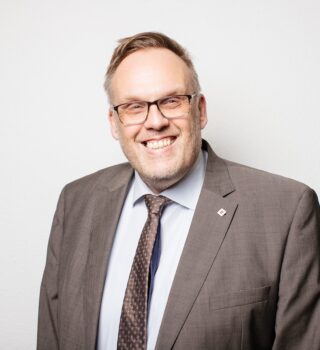 Klaus Puschmann Geschäftsführer GPS Mann Brille lachen brauner Anzug