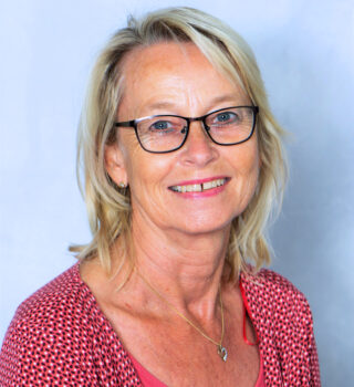 Karin Riedel. Eine Frau mit Brille und blonden schulterlangen Haaren