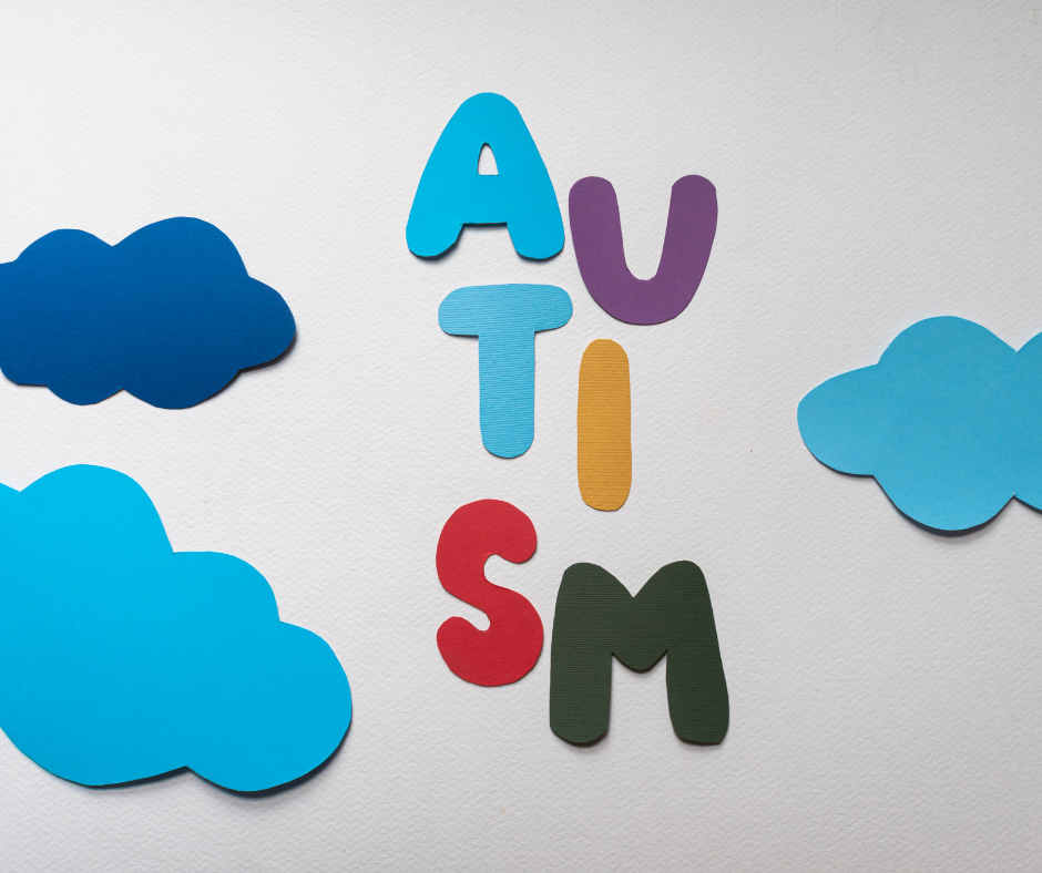 Drei blaue Wolken aus Papier und sechs Buschstaben aus Papier, das zusammen als Wort "Autism" gelesen wird. Es heißt von Englisch auf Deutsch "Autismus".