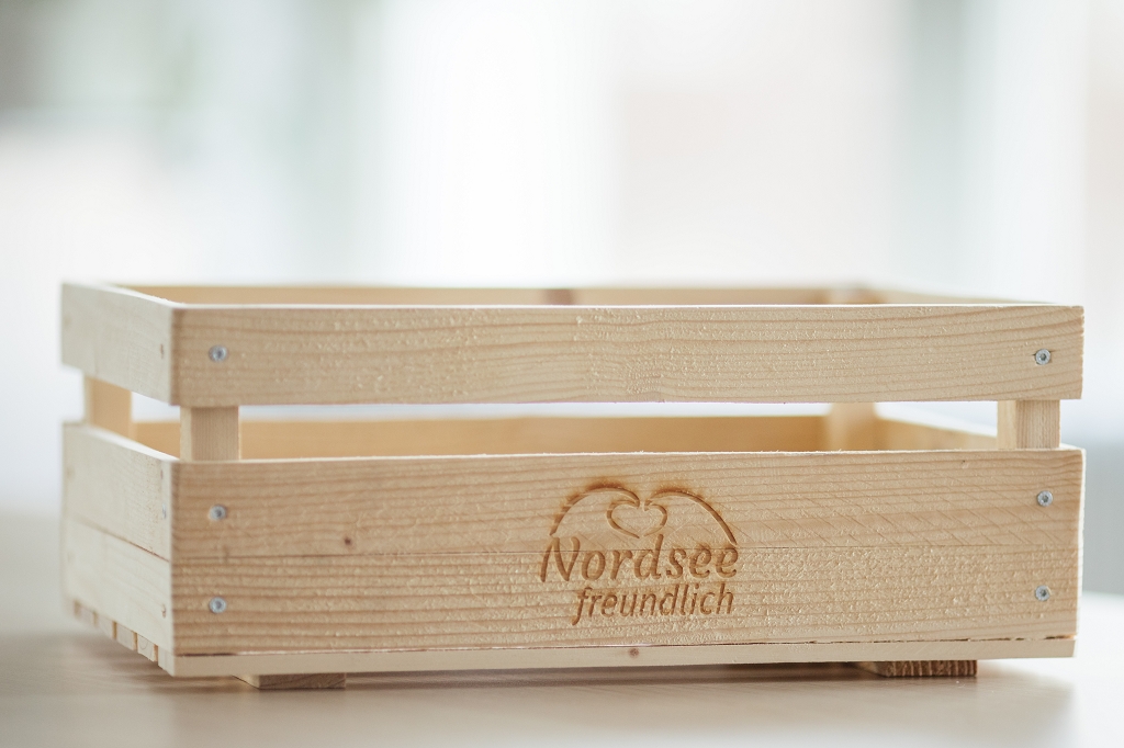 Ein selbstgebauter Kasten aus Holz mit dem Logo "Nordseefreundlich".