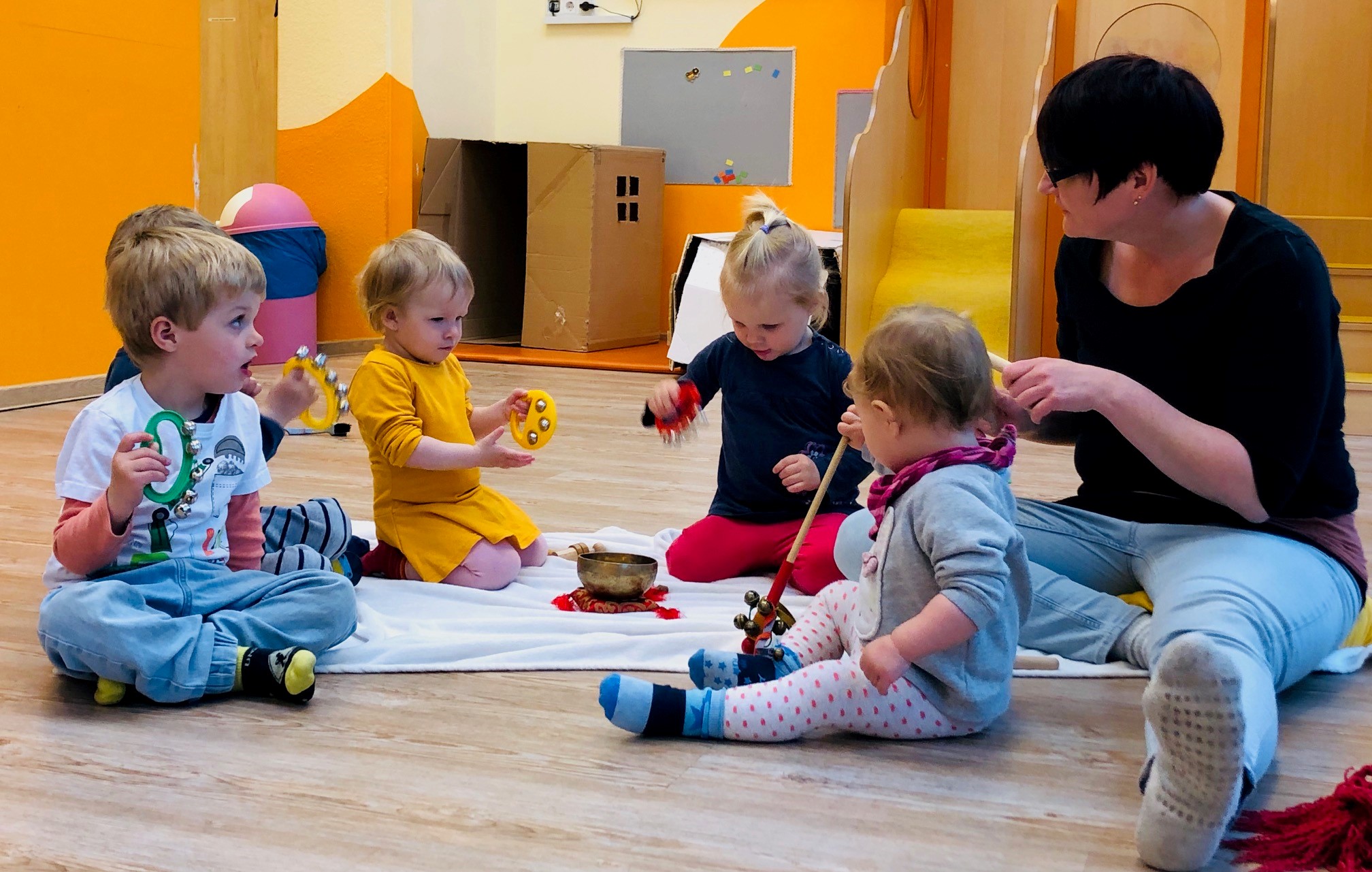 Kinder spielen mit einer Erzieherin