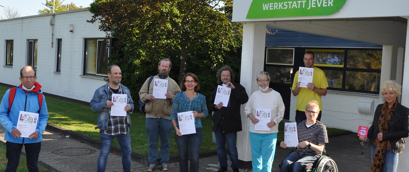 Gruppenfoto Büro für Leichte Sprache und Werkstatt Jever mit Zeitungen LeiSa