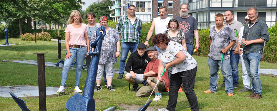 Man sieht Mitarbeiter der Tagesstätte Ebkeriege und Beschäftigte beim Minigolfplatz beim Havenhaus Minigolf draußen spielen