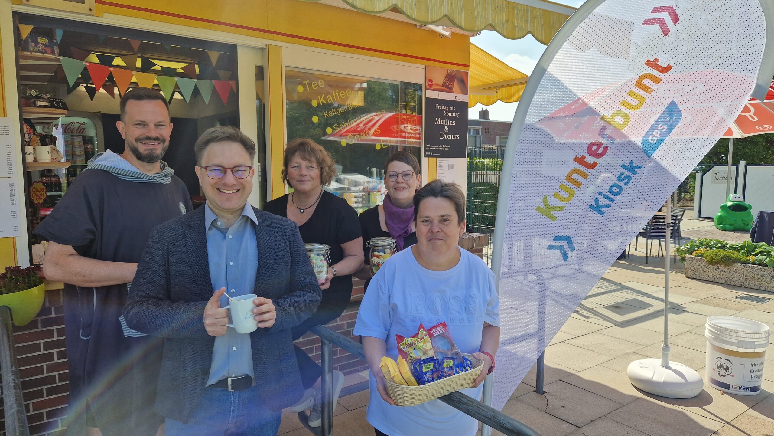 Draußen vor dem Kiosk Kunterbunt. Man sieht einen GPS Mitarbeiter, eine GPS Beschäftigte, den Bürgermeister von Jever und zwei andere Frauen auf dem Bild.