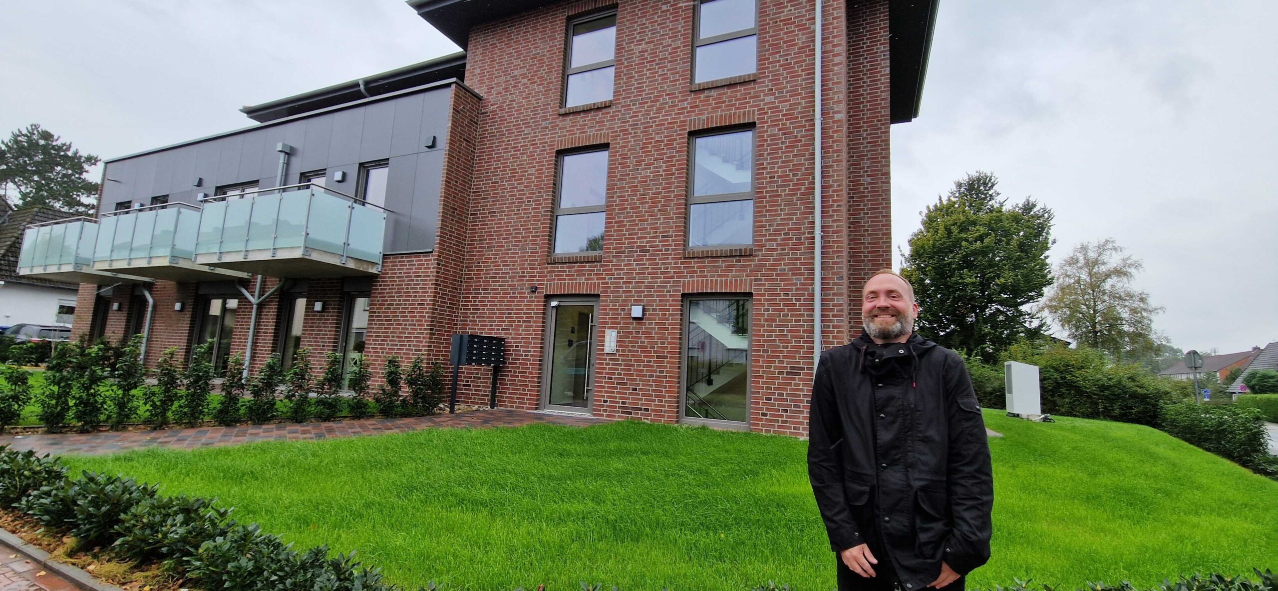 Ein Mann mit dem Namen Oliver Kuhnt steht vor dem Gebäude des Appartemenwohnen "An der Wiek" in Westerstede. Der Mann auf dem Bild ist der Leiter des Wohnverbundes Soziale Psychiatrie bei der GPS.